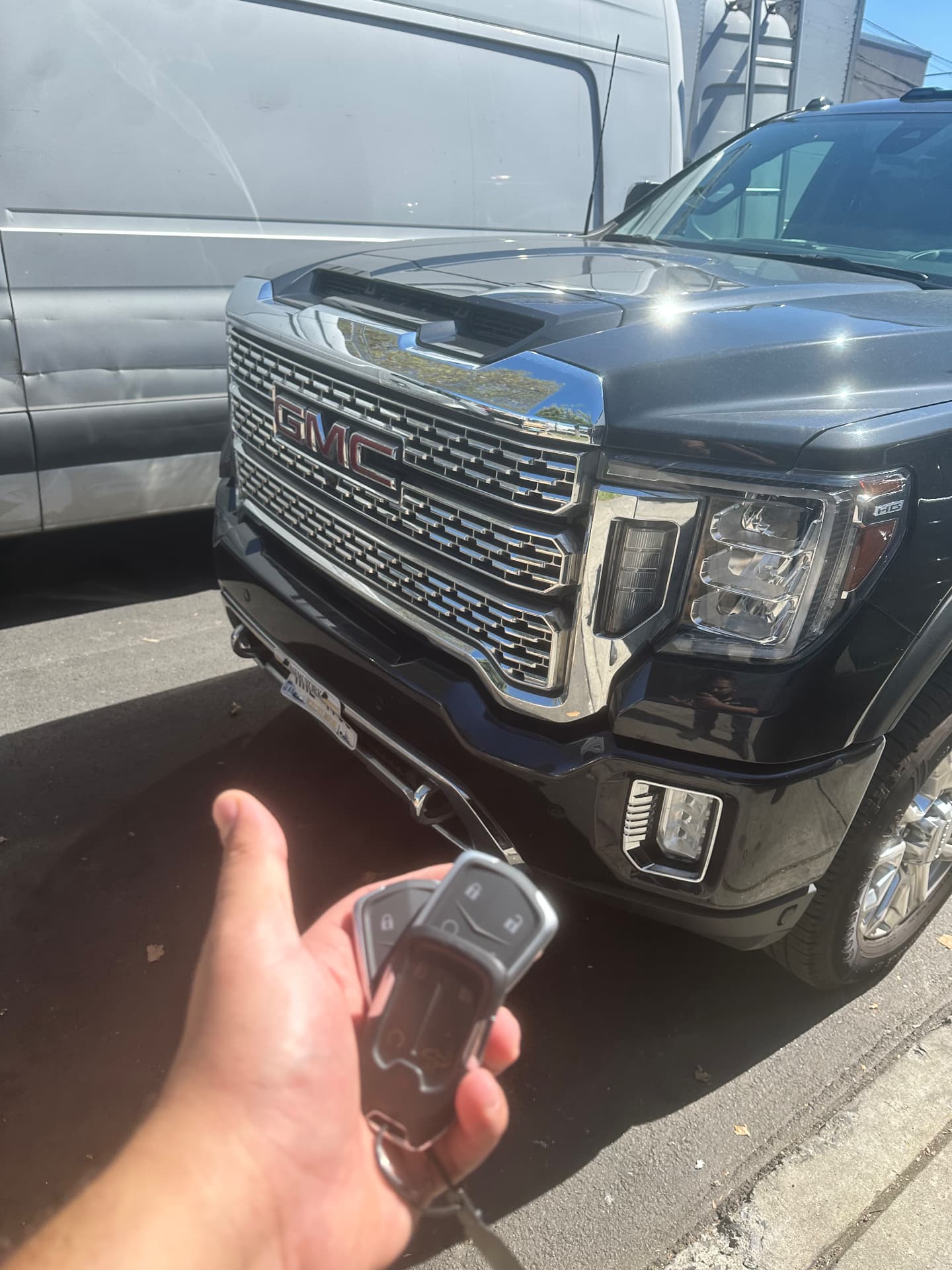 GMC Denali smart remote key in hand in front of the truck